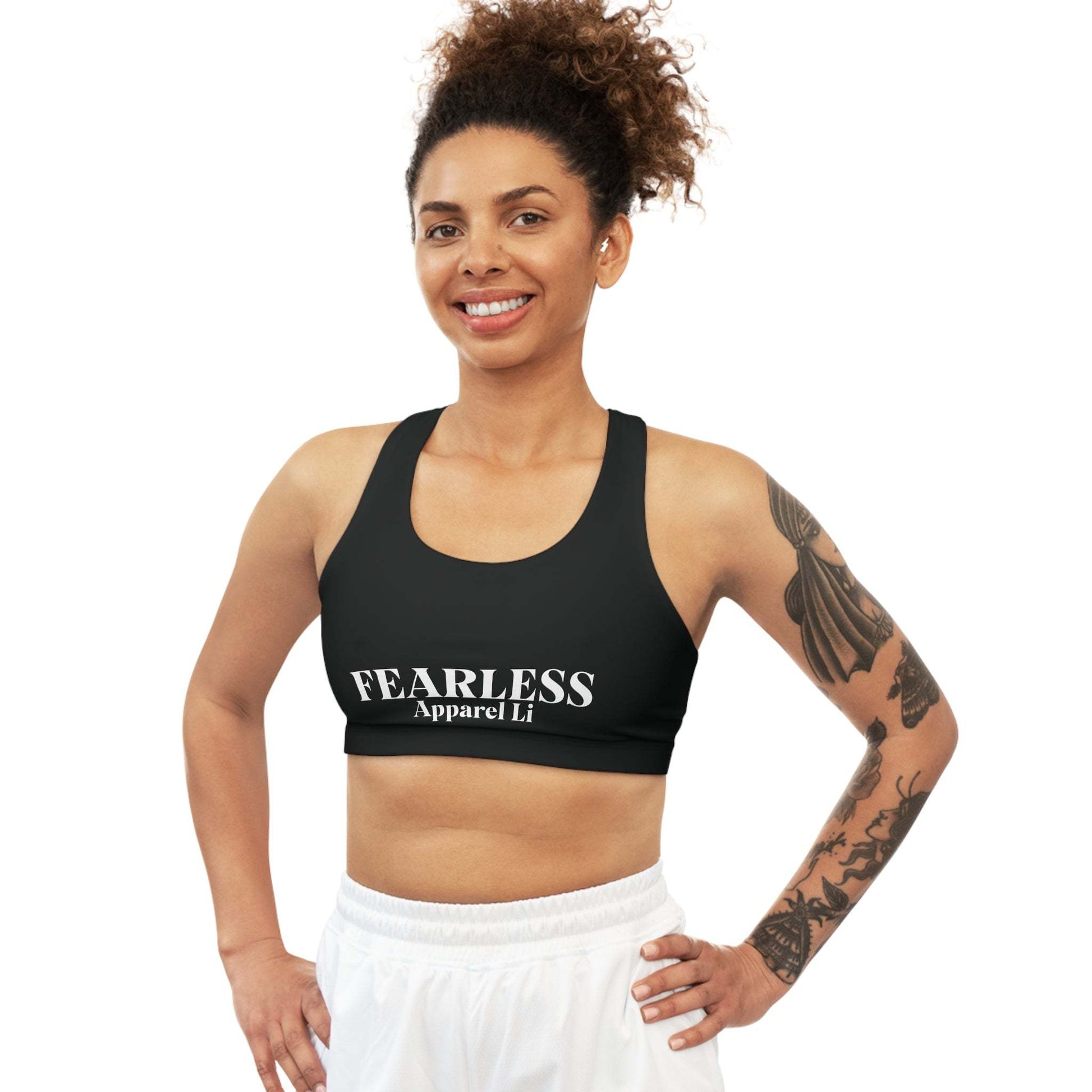 Woman wearing a Seamless Sports Bra Fearlessli in black with bold lettering.