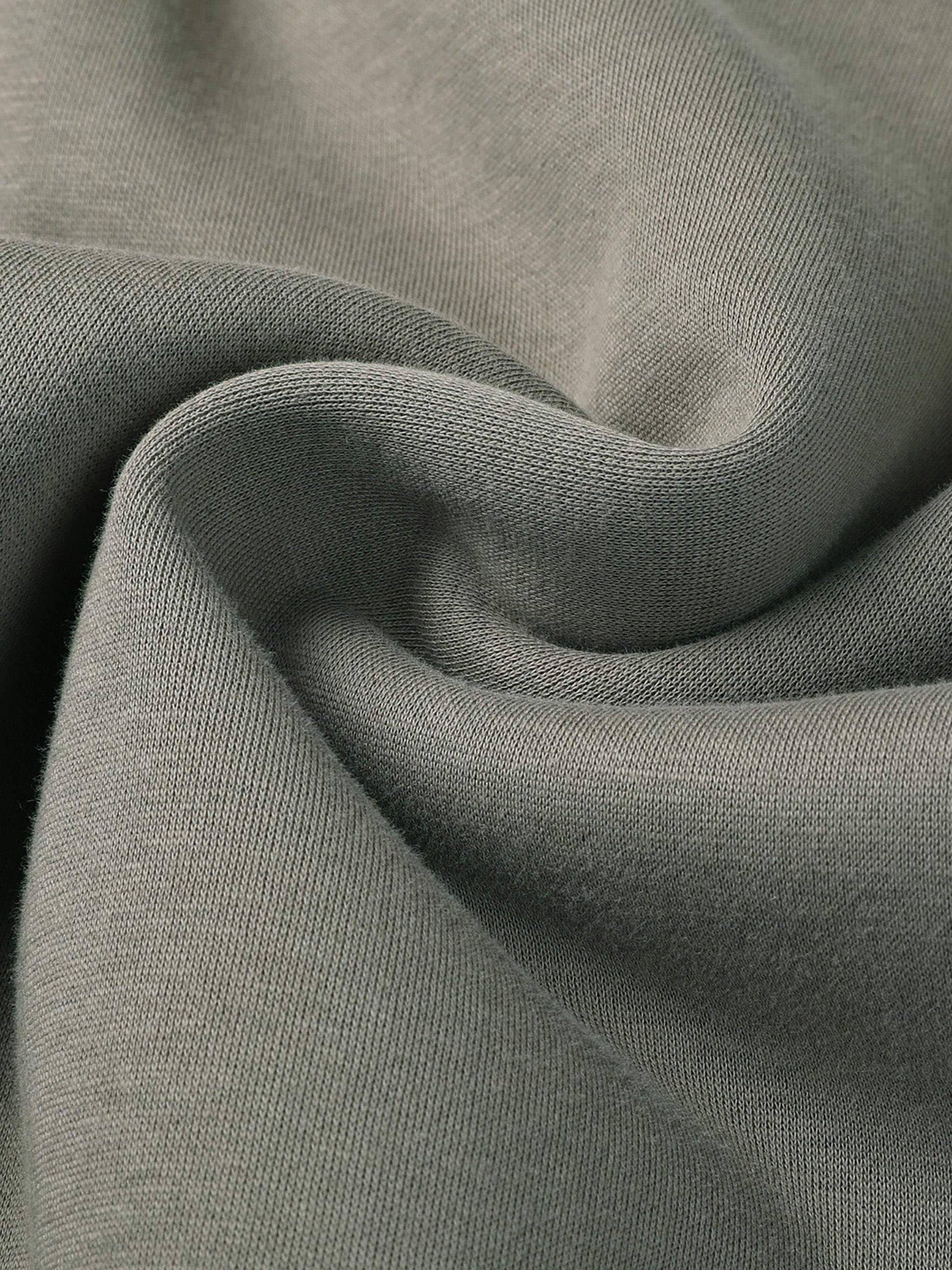Close-up of green fabric from Fearless Apparel Line Street Drawstring Sweatpants, showing texture and quality.