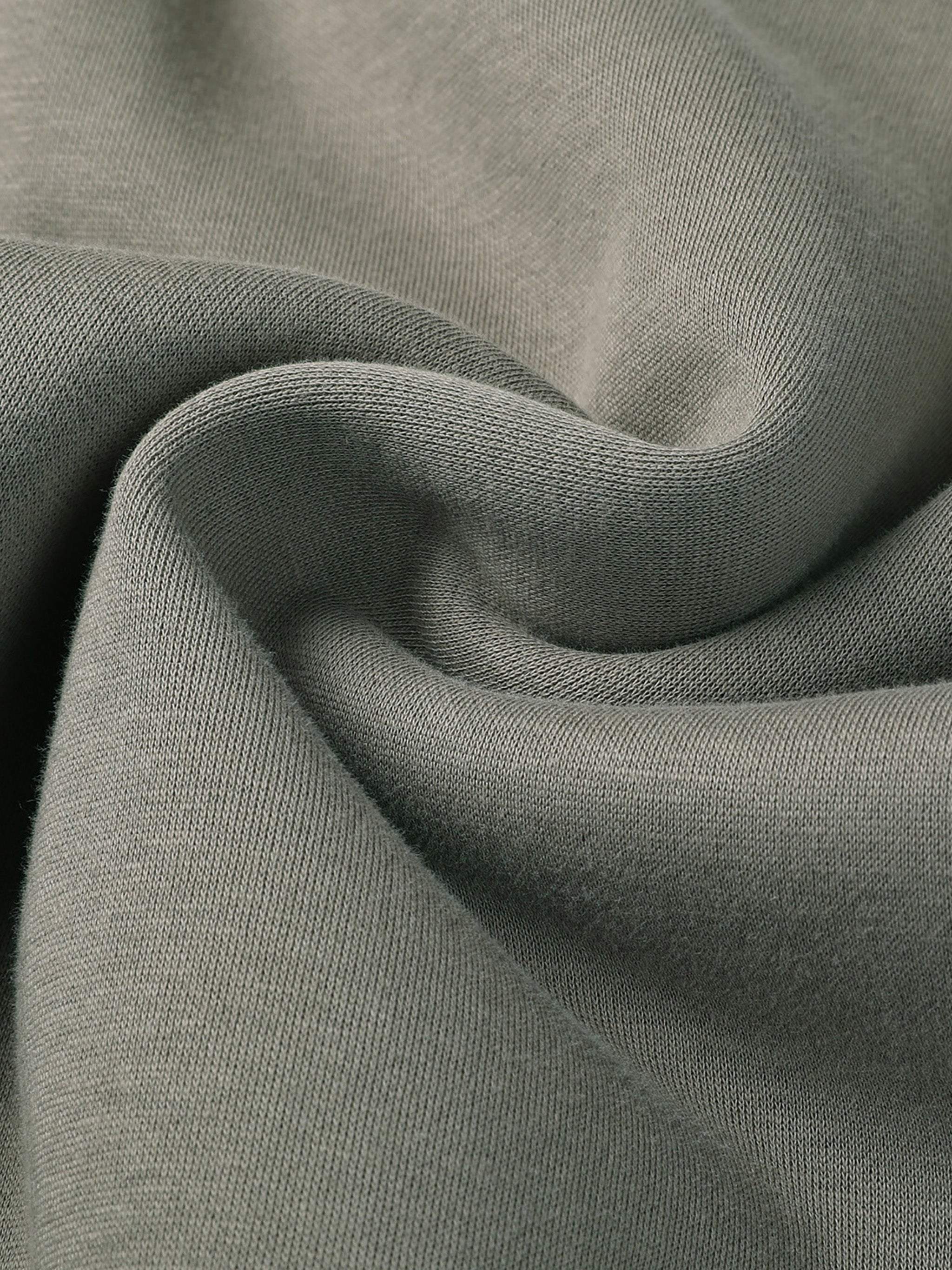 Close-up of green fabric from Fearless Apparel Line Street Drawstring Sweatpants, showing texture and quality.