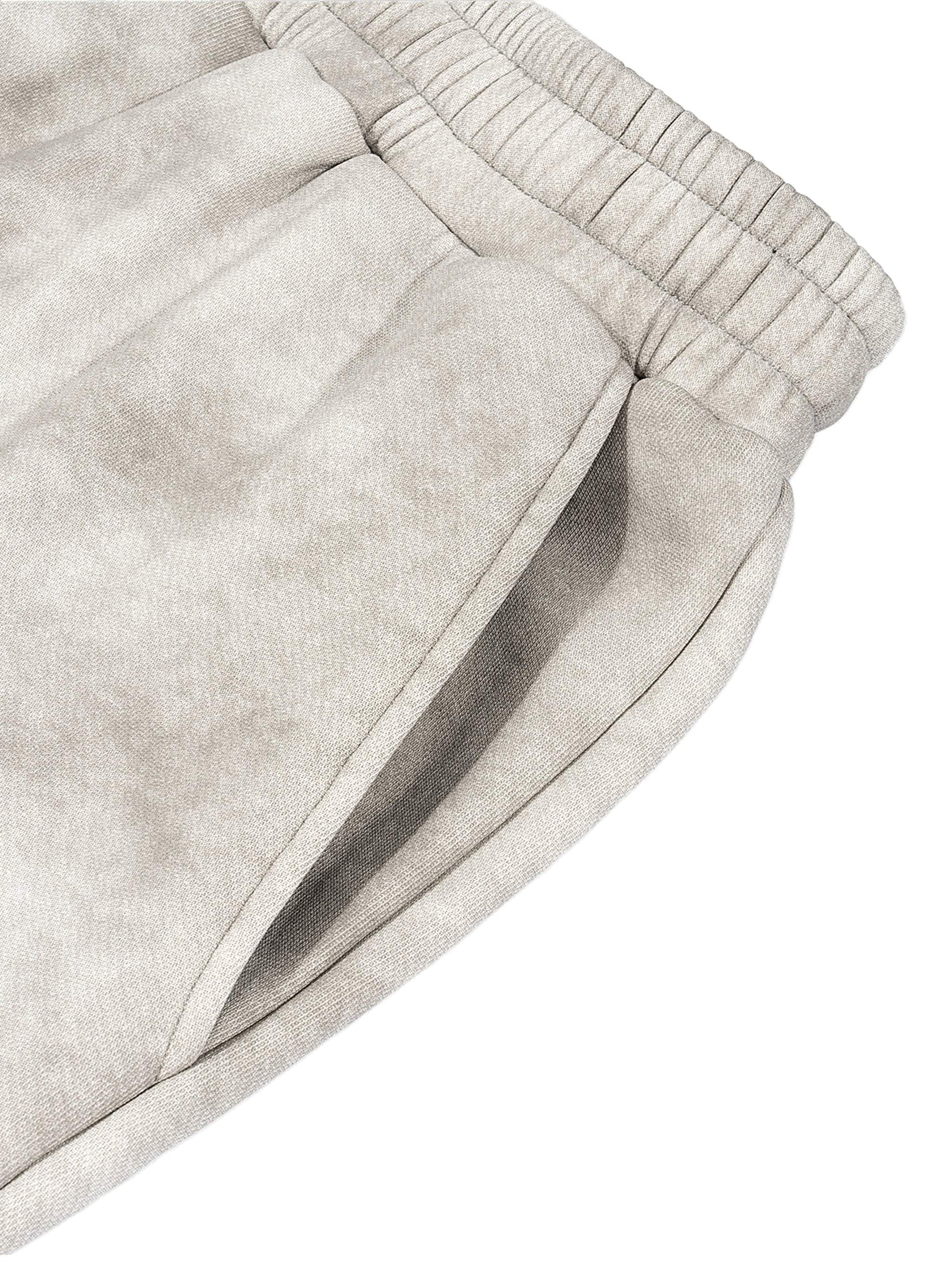 Dirty washed fleece sweatpants close-up showing elastic waistband and side pocket in grey.