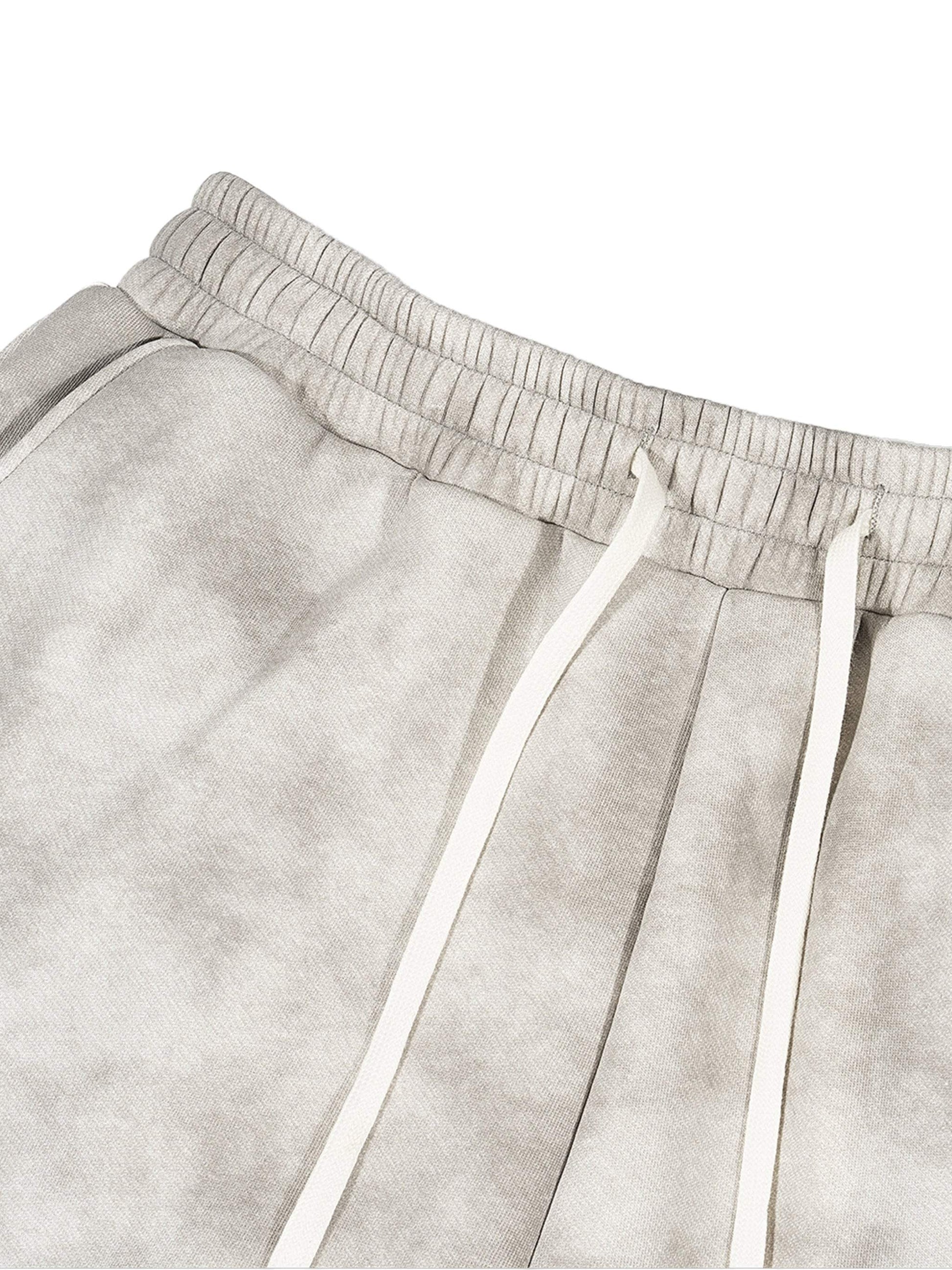 Dirty washed fleece sweatpants in grey with drawstring, displaying relaxed fit and versatile style.