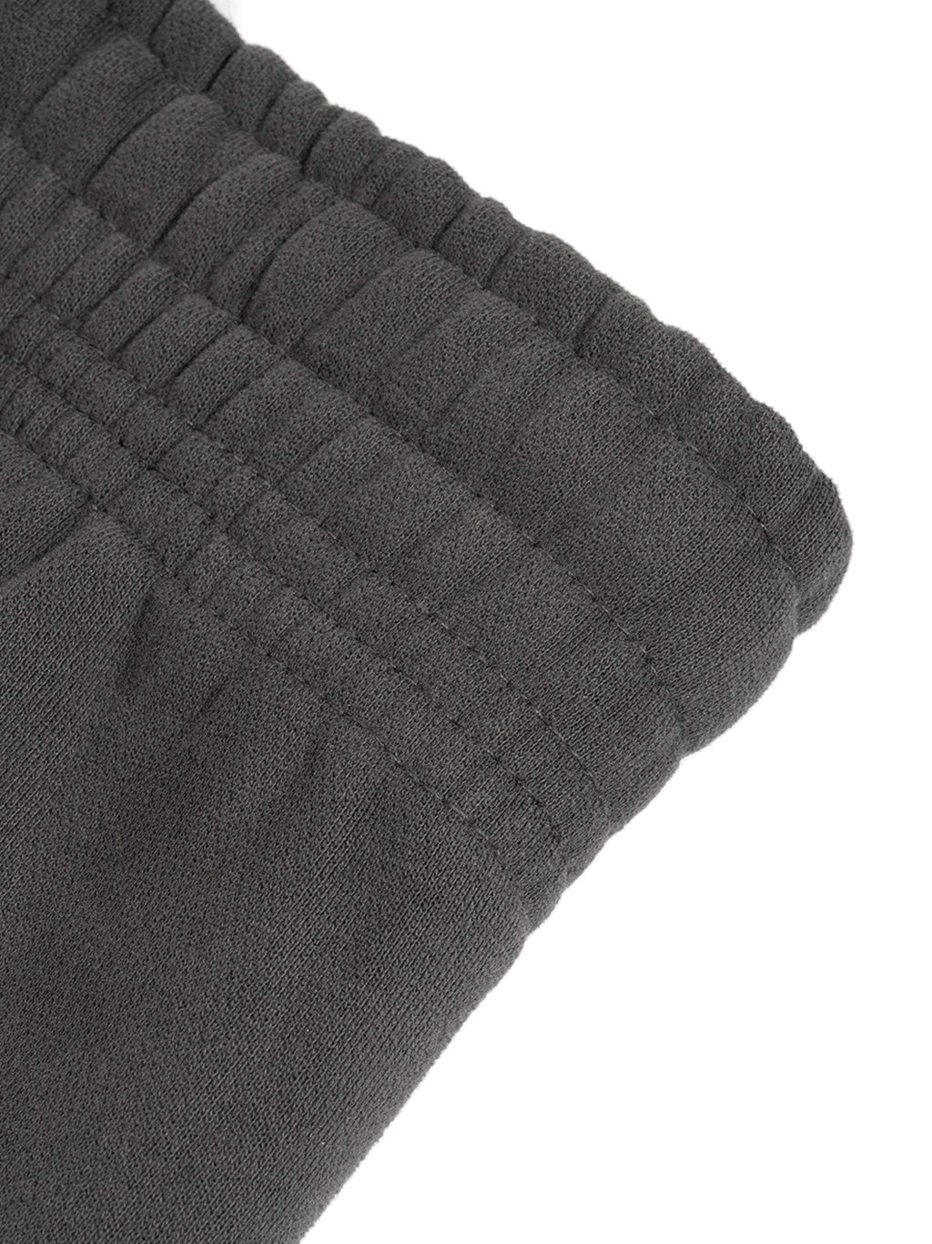 Close-up of black Sunfade Curved Blade Sweatpants waistband, showcasing detailed stitching and elastic design.