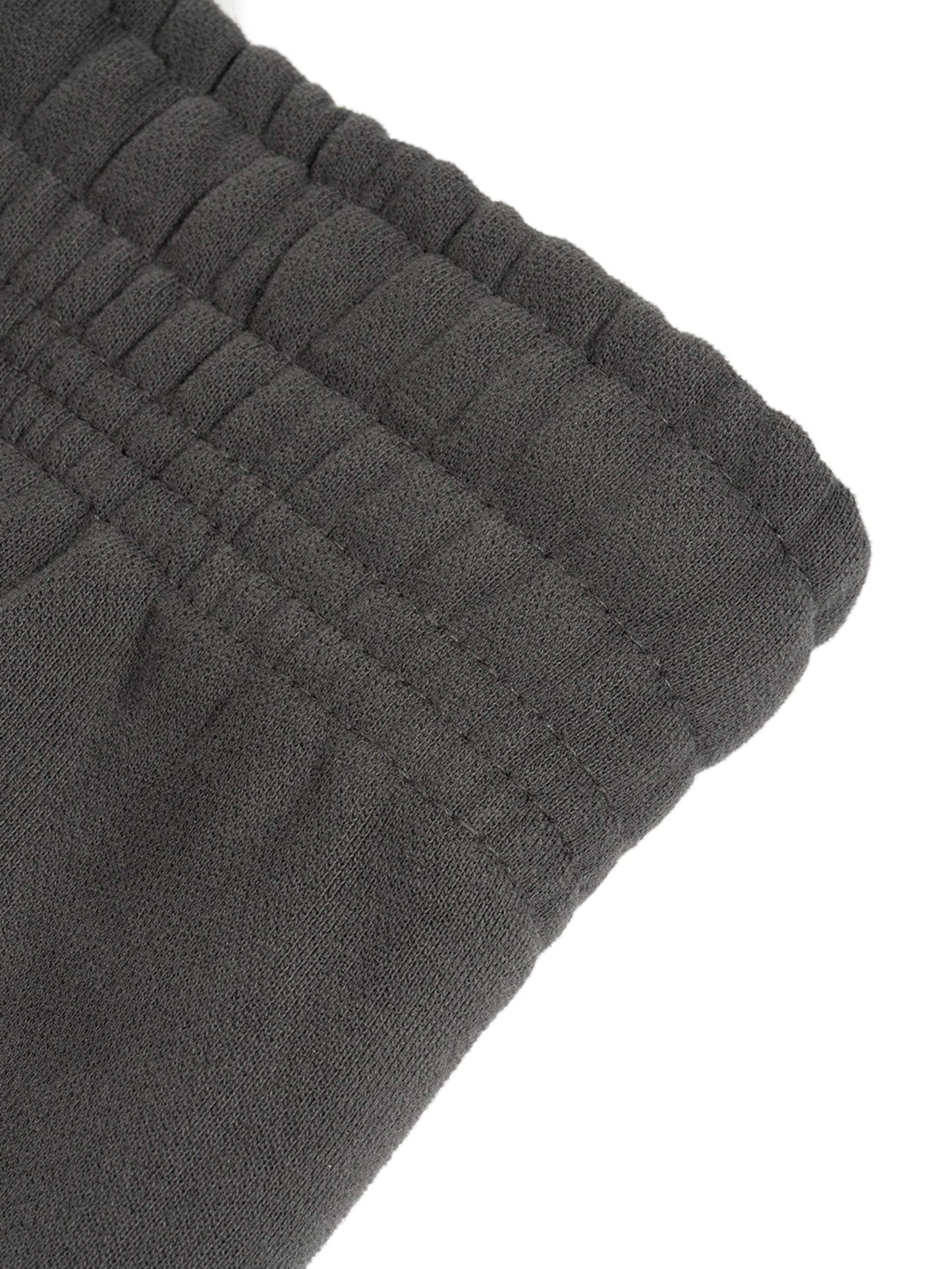 Close-up of black Sunfade Curved Blade Sweatpants waistband, showcasing detailed stitching and elastic design.