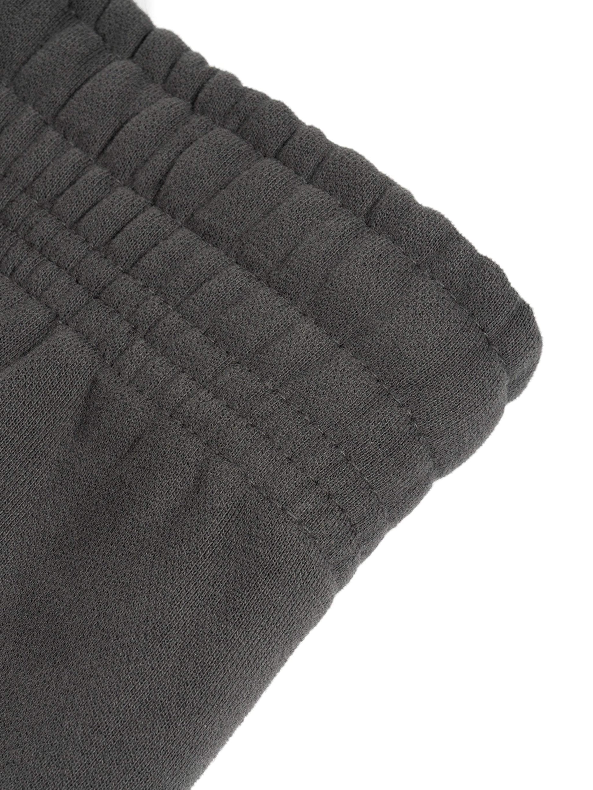 Close-up of black Sunfade Curved Blade Sweatpants waistband, showcasing detailed stitching and elastic design.