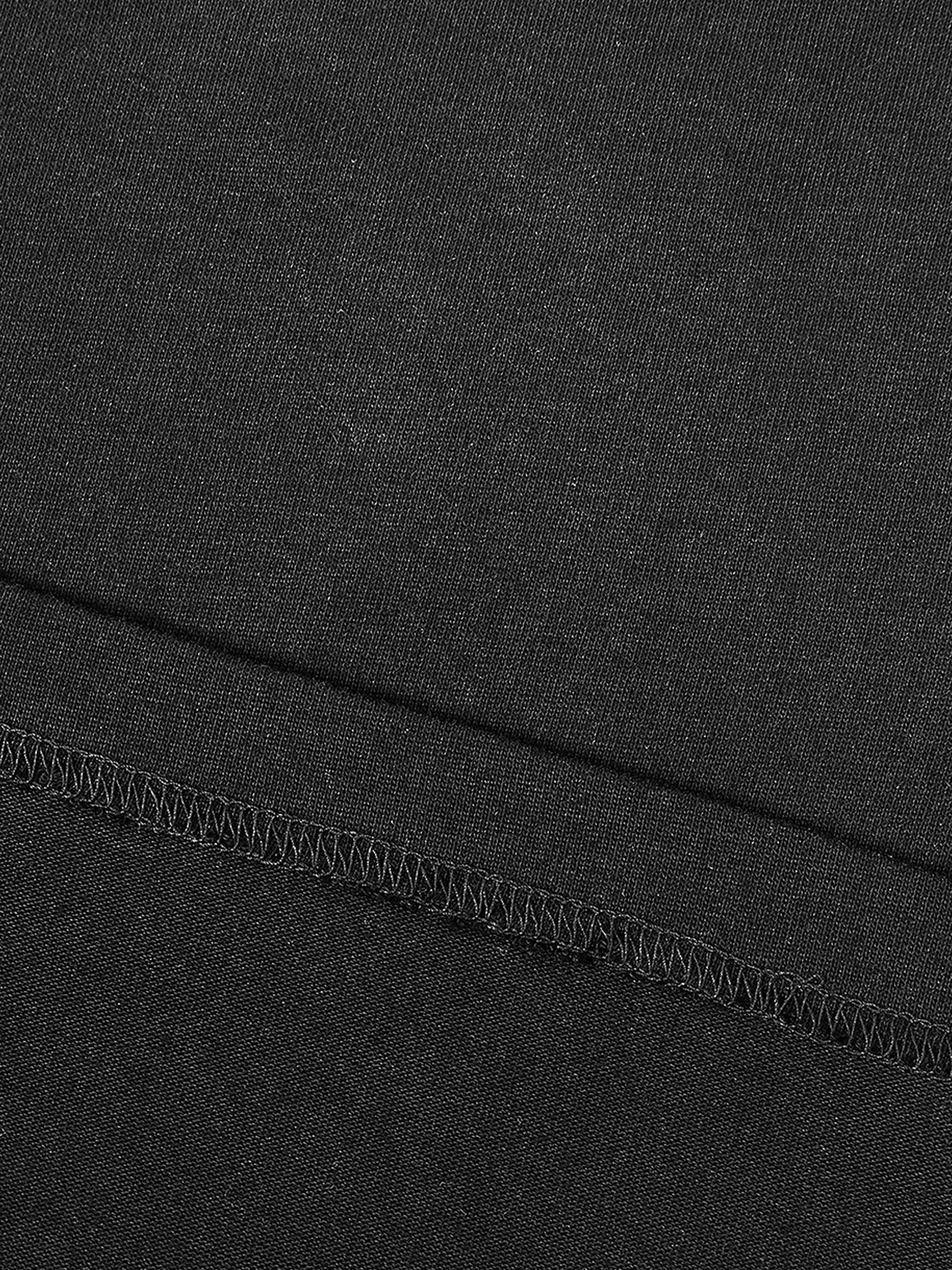 Contrast piped panel detail on black unisex cotton and polyester t-shirt, loose model.